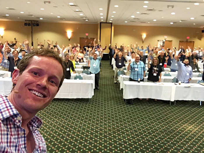 Aidan Booth with a room full of business builders at a live event